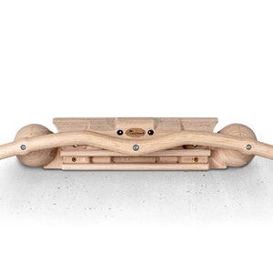 Könnte beinhalten: Eine Holz-Klimmzugstange mit zwei gebogenen Griffen und einer Holzplattform mit einer Reihe von Holzblöcken. Die Stange ist an einer Wand montiert.