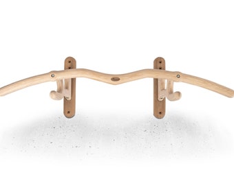 May include: A wooden wall-mounted bike rack with two hooks. The rack is made of natural wood and has a curved design.