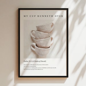 Puede incluir: Una impresión enmarcada con un fondo blanco y una pila de cuatro tazas de cerámica blanca. El texto "MY CUP RUNNETH OVER" está en la parte superior de la impresión. Debajo de las tazas, el texto "Psalm 23:5 (A Psalm of David)" está impreso. El texto continúa con un versículo de la Biblia: "Thou preparest a table before me in the presence of mine enemies: thou anointest my head with oil; my cup runneth over. Surely goodness and mercy shall follow me all the days of my life: and I will dwell in the house of the LORD for ever."