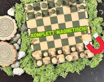 May include: A magnetic chess set with a green and tan checkered board and wooden pieces. The pieces are various shapes and colors. The text "KOMPLETT MAGNETISCH" is across the board. The set is surrounded by green moss and decorative stones.