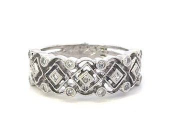 May include: A silver band ring with a delicate design featuring small diamonds set in a geometric pattern.