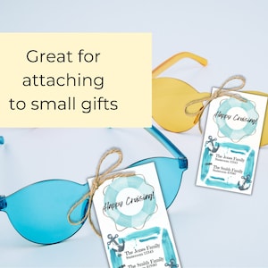 Puede incluir: Dos gafas de sol azules y amarillas con una etiqueta de regalo blanca unida a una de las gafas de sol. La etiqueta de regalo tiene un dise&ntilde;o de acuarela azul y verde con un salvavidas y el texto "Happy Cruising!" The Jones Family Stateroom 12345 The Smith Family 67590
