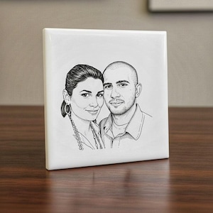 May include: A square, white ceramic tile with a black and white sketch of a couple. The artwork shows a man and woman, both facing the viewer. The tile is presented on a wooden surface.