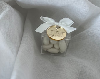 May include: A small clear box filled with white candy, tied with a white satin ribbon and a gold tag that reads "Appreciate your attendance 23.12.2023 Lily & Peter"