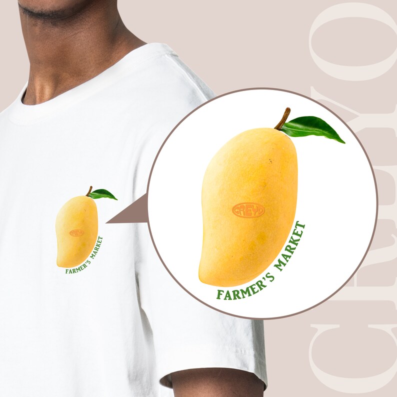 May include: White t-shirt with a yellow mango graphic and the text "Farmer's Market" printed on it.