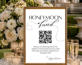 May include: A rectangular gold-framed sign with white background and black text reading HONEYMOON fund, featuring a small airplane icon, a QR code, and the text Thank you for celebrating with us! Your presence is most important, but if you would like to give a gift, please contribute to our honeymoon fund! XO Sydney and Cameron.