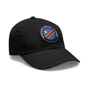 May include: Black baseball cap with a circular patch featuring the flag of the Democratic Republic of the Congo. The patch has white text that reads "Democratic Republic of Congo".