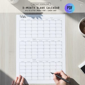 May include: A 3-month blank calendar printable in PDF format. The calendar is on white paper with a minimalist design, featuring boxes for each day of the month. The text "3-MONTH BLANK CALENDAR" is visible at the top. A hand is holding a pen.