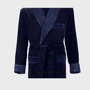 May include: A navy blue velvet robe with a quilted satin collar and cuffs. The robe has a self-tie belt and two patch pockets.