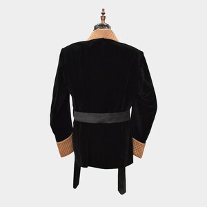 May include: A black velvet robe with a brown velvet collar and cuffs. The robe has a black satin sash.