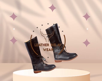 May include: Two pairs of brown leather riding boots with laces. The boots are on a white pedestal against a light pink background with a brown logo that says "Leather Relay Wear".