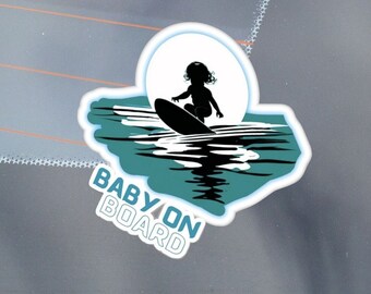 May include: A blue and white car sticker with a silhouette of a child surfing on a wave. The text "BABY ON BOARD" is written in white letters on a blue background.