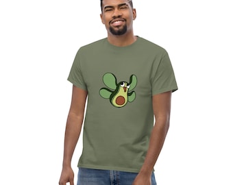 Op de afbeelding: Een groen T-shirt met een cartoon avocado met vleugels. De avocado heeft een bruine pit en een verraste uitdrukking.