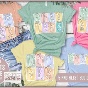 May include: A collection of colorful t-shirts featuring team mascots. Each shirt displays a team name like "Titans", "Spartans", "Sharks", "Wolves", and "Stars" in a decorative font. The shirts are in various colors, including peach, green, pink, yellow, and blue.