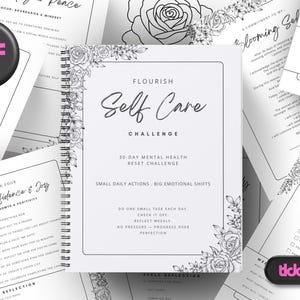 Op de afbeelding: Een wit spiraalgebonden tijdschrift met de titel "Flourish Self Care Challenge" met bloemenhoekontwerpen. Verschillende witte pagina's met zelfzorgprompts omringen het tijdschrift, samen met een zwarte knop met de tekst "7 PDF files".