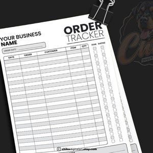 May include: A black and white order tracker sheet with the text "ORDER TRACKER" and spaces for order details. The sheet is held together with a black binder clip. The sheet includes fields for date, order, customer, item, quantity, and shipping status.
