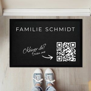 Könnte beinhalten: Schwarze Fußmatte mit weißem Text "Familie Schmidt" und einem QR-Code mit dem Text "Keiner da? Scan me" und einem Pfeil, der auf den QR-Code zeigt.