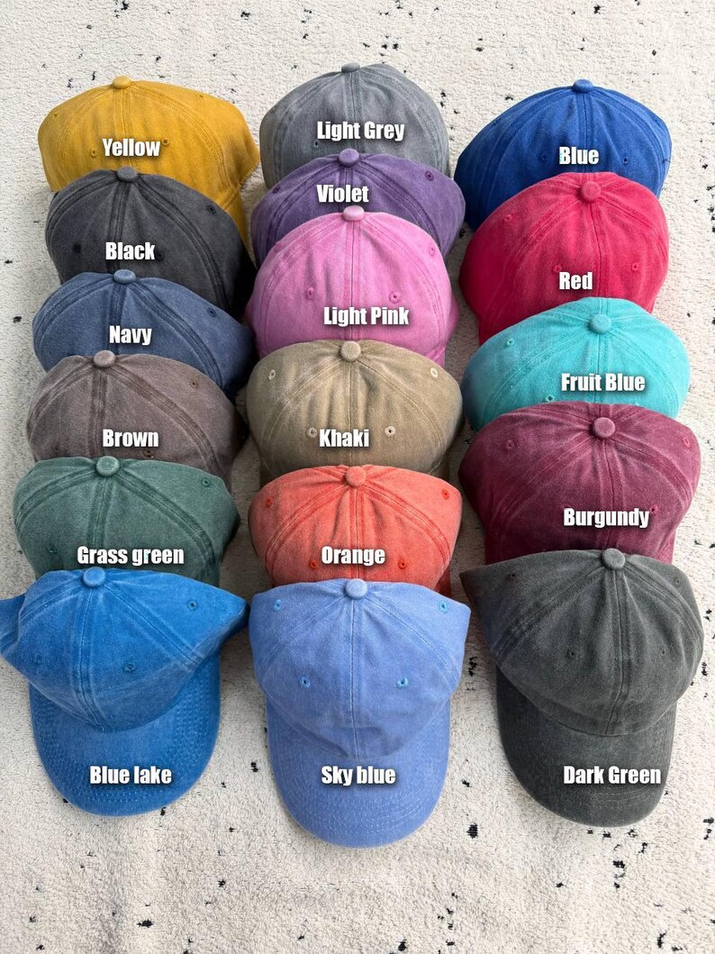 Op de afbeelding: Een verzameling baseballpetten in diverse kleuren, waaronder geel, lichtgrijs, blauw, violet, zwart, rood, lichtroze, marineblauw, fruitblauw, bruin, kaki, bordeaux, grasgroen, oranje, blauw meer, hemelsblauw en donkergroen. Elke pet heeft een gebogen klep.