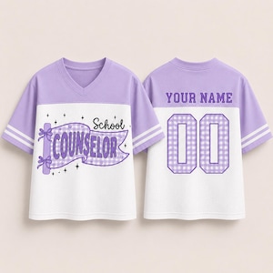 May include: A lavender and white V-neck jersey with short sleeves and double white stripes. The front features a purple gingham banner with the text School COUNSELOR and stars. The back displays the text YOUR NAME above the number 00.