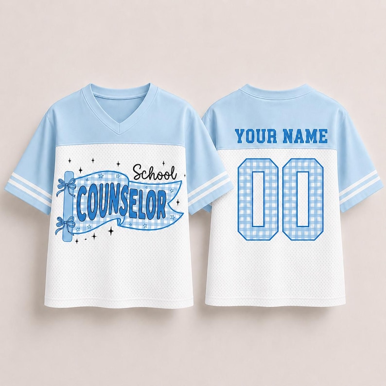 May include: A light blue and white V-neck jersey with short sleeves and double white stripes. The front features a blue gingham banner with the text School COUNSELOR and star accents. The back displays the text YOUR NAME above the number 00.