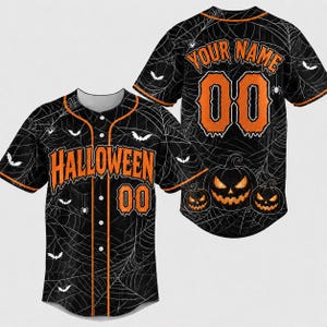 May include: A black baseball jersey with an orange spiderweb pattern, bats, and three jack-o'-lanterns. The front features the text HALLOWEEN and the number 00 in orange. The back displays the text YOUR NAME and the number 00 in orange.