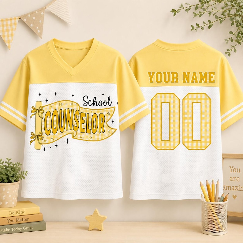 May include: A yellow and white V-neck jersey featuring a yellow banner graphic with the text School COUNSELOR on the front and the text YOUR NAME above the number 00 on the back. The shirt has short sleeves with two white stripes on each arm.