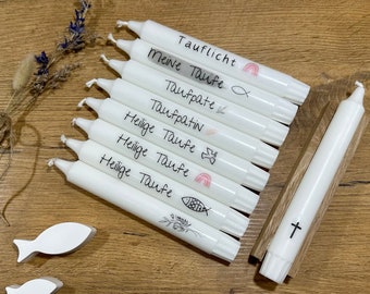 May include: A set of white candles with handwritten labels for a christening ceremony. The labels include "Tauflicht", "Meine Taufe", "Taufpate", "Taufpatin", and "Heilige Taufe" with various symbols like a fish, a rainbow, and a dove.