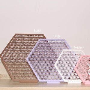 以下が含まれることがあります： 茶色、ラベンダー、白、ピンクなど、さまざまなサイズと色の装飾的な六角形のパネルのコレクション。各パネルには詳細な幾何学模様があります。ぬいぐるみと小さな置物も存在します。