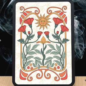 May include: A rectangular black case featuring a floral design with a smiling sun, red flowers, and green leaves. The design is set against a cream background. The case has the text "REGGIE'S HUT" and a logo of a tiki head.