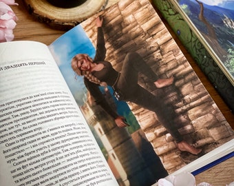 May include: A woman in a black outfit climbs a stone wall. She is reaching for a gold flag at the top of the wall. The text "Twenty-first" is visible on the page.
