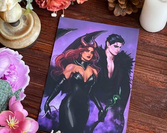 May include: A purple and black fantasy art print featuring a woman with horns and a man with a dark expression. The woman is wearing a black dress and holding a staff. The man is wearing a black suit and has a snake wrapped around his arm.