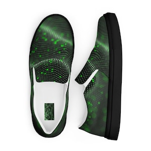 May include: Pair of slip-on shoes with a black sole and a green and black pattern. The design features a wavy, dotted pattern with scattered green dots. The interior is white, and the shoes have a small graphic on the inner heel.