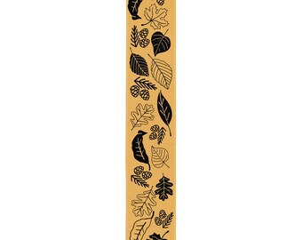 May include: A tan bookmark with a repeating pattern of black leaf and pinecone illustrations. The design includes various leaf shapes and pinecones, creating a nature-inspired theme. The bookmark is a vertical rectangle.