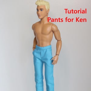 以下が含まれることがあります： 水色のズボンと茶色の靴を履いた人形。テキスト「Tutorial Pants for Ken」は赤色で表示されています。人形は金髪で、上半身裸です。