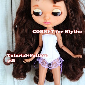 May include: A white corset with a purple lace trim for a Blythe doll. The doll has long brown hair and is wearing the corset. The text "CORSET for Blythe" and "Tutorial+Pattern pdf" is visible in the image.