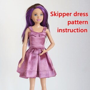 May include: A purple dress with a bow on the bodice, made for a Skipper doll. The dress is a light purple color and has a satin finish. The doll has purple hair and blue eyes.