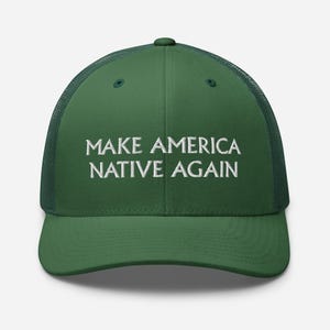 May include: Green trucker hat with the text "MAKE AMERICA NATIVE AGAIN" in white block letters. The hat has a mesh back and a curved brim. The hat is a solid green color.