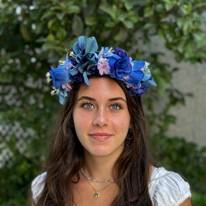 Corona de flores celestes y moradas