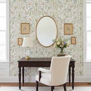 May include: A dark wood desk with a pleated lamp, an oval mirror, and a cream upholstered chair. The wall features floral wallpaper with birds. Four small framed botanical prints hang on the wall, and a glass vase holds a bouquet of flowers.
