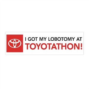 Puede incluir: Una pegatina para parachoques blanca con fondo rojo y el logotipo de Toyota. El texto de la pegatina dice "I got my lobotomy at TOYOTATHON!"