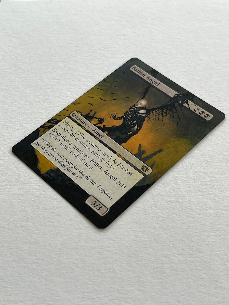 May include: A Magic: The Gathering card featuring a Fallen Angel. The card has a black border with the text "Fallen Angel" at the top. The artwork depicts a dark angel figure with outstretched wings against a sepia-toned background. The card's text describes its abilities.