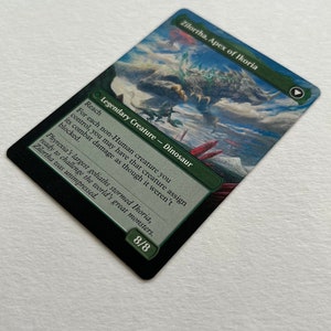 May include: A green, blue, and white fantasy art card depicting a large, green, dinosaur-like creature with a long neck and tail. The card is titled "Zilortha, Apex of Ikoria" and has the text "Legendary Creature - Dinosaur" and "Reach" on it. The card is from the Magic: The Gathering trading card game.