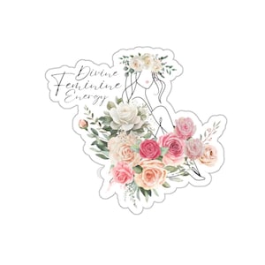 May include: A sticker with a line drawing of a woman with a floral crown, sitting amongst pink and white watercolor flowers. The text "Divine Feminine Energy" is written in cursive.