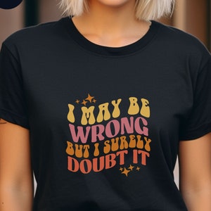 Può includere: Maglietta nera con una grafica in stile retrò che dice "Potrei sbagliarmi, ma lo dubito fortemente".
