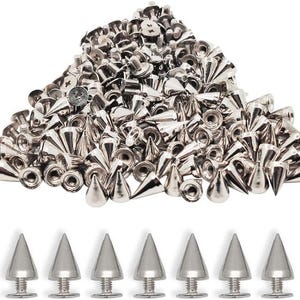 以下が含まれることがあります： 銀色の金属製コーンスタッドとネジ留めスタッドの山。スタッドは様々なサイズと形状で、光沢のある反射面を持っています。7つの個々のスタッドが画像の下部に並んでいます。