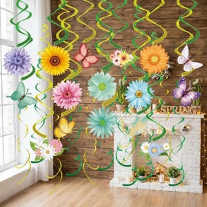 May include: A set of hanging decorations featuring yellow and green plastic spirals adorned with paper cutouts of colorful flowers, including sunflowers, daisies, and gerberas, alongside various butterflies in shades of pink, purple, and yellow.