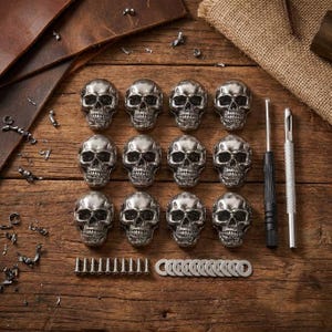 Peut inclure: Un ensemble de douze pièces de quincaillerie en métal argenté en forme de crâne disposées en grille. Le lot comprend douze petites vis métalliques et douze rondelles plates, accompagnées d'un tournevis à manche noir et d'un outil en métal.