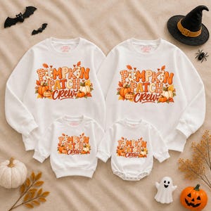 May include: Two white long-sleeve sweatshirts and two white long-sleeve baby bodysuits featuring a graphic print of orange pumpkins and autumn leaves with the text PUMPKIN PATCH CREW in orange and plaid patterns on the front of each garment.