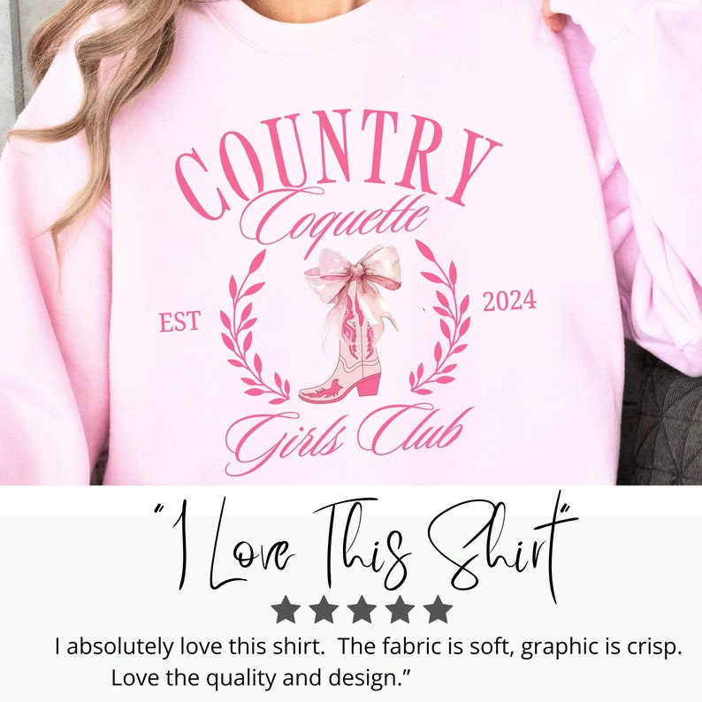 May include: Pink sweatshirt featuring a graphic design of pink cowboy boots with a bow, a wreath of leaves, and the text "COUNTRY Coquette EST 2024 Girls Club". The text "I Love This Shirt" is written below the graphic.