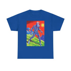 May include: A royal blue t-shirt with a graphic print of a blue, skeletal, humanoid figure with a red skull-like head. The figure is standing on a green, grassy field with a red, orange, and yellow background.